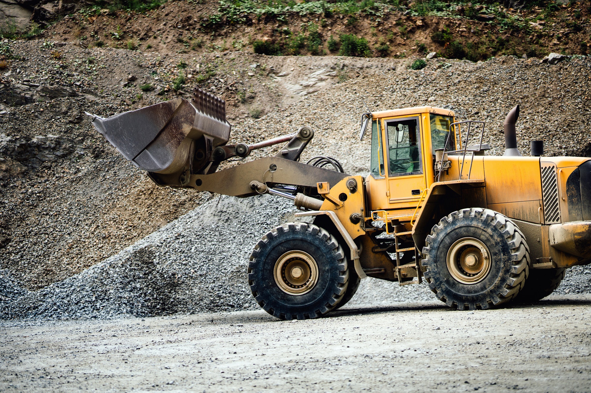 Close up details of wheel loader with scoop working on construction site